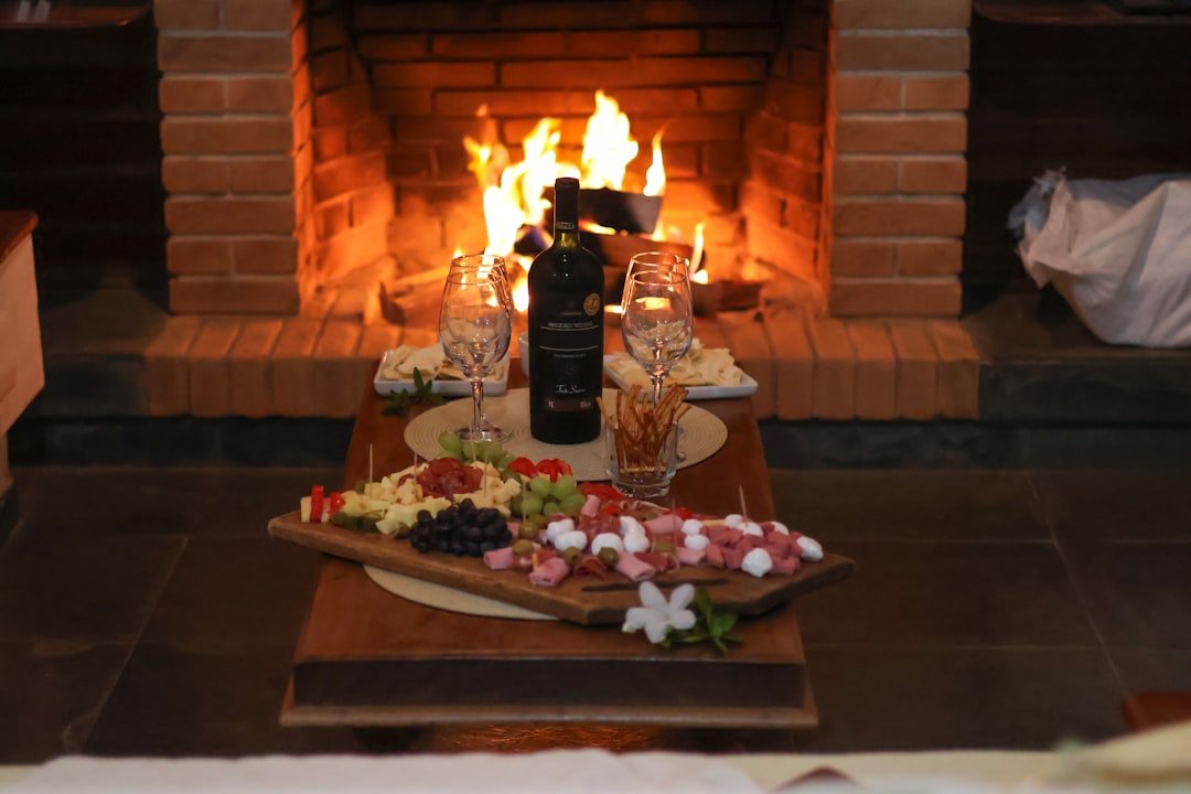 A cozy fireplace with wine and a charcuterie board